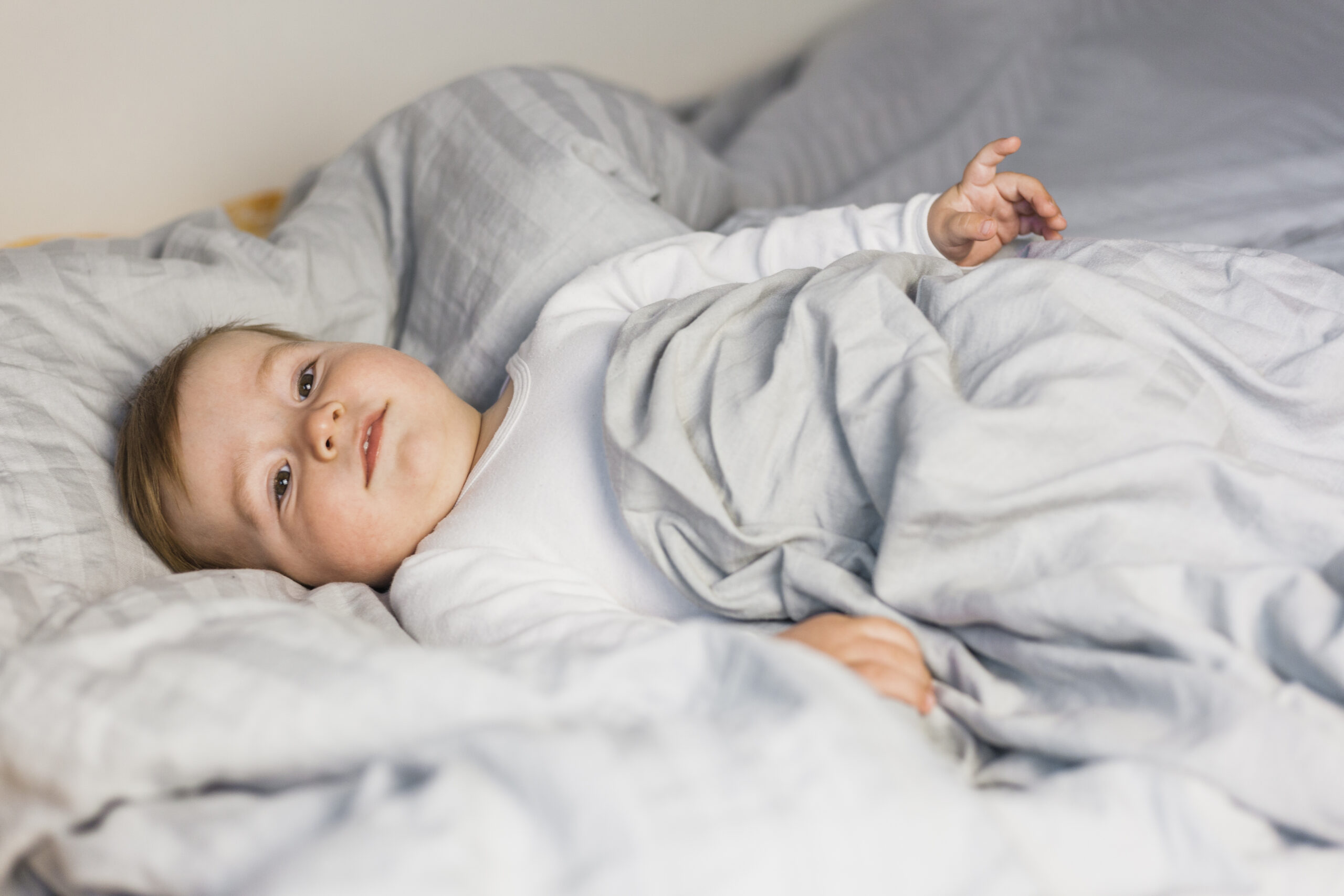 cute blonde baby white bed with blankets